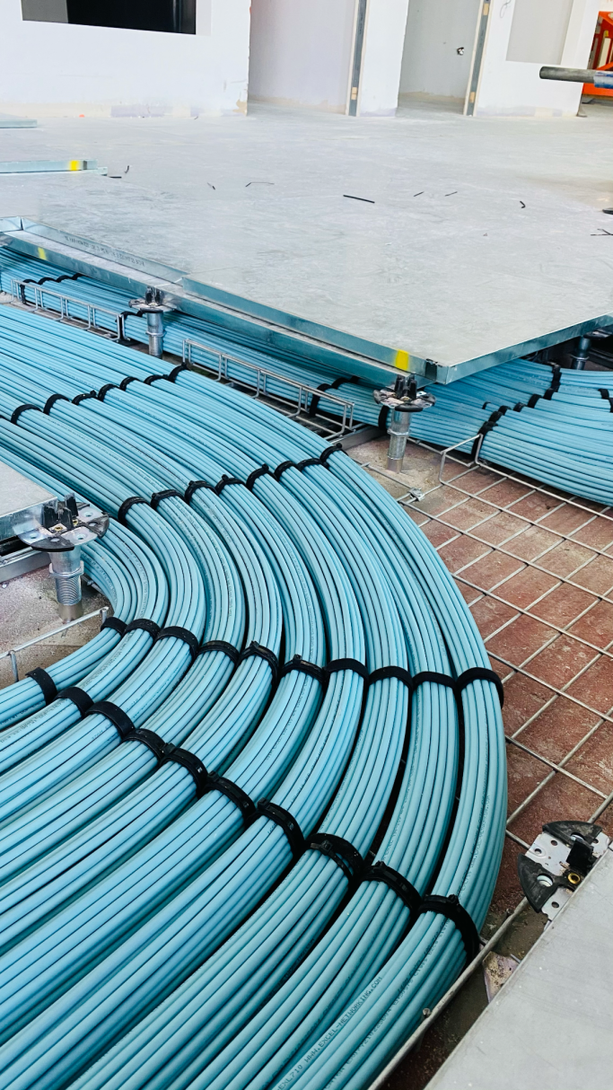 Blue cables are neatly arranged on the floor, with some sections coiled.